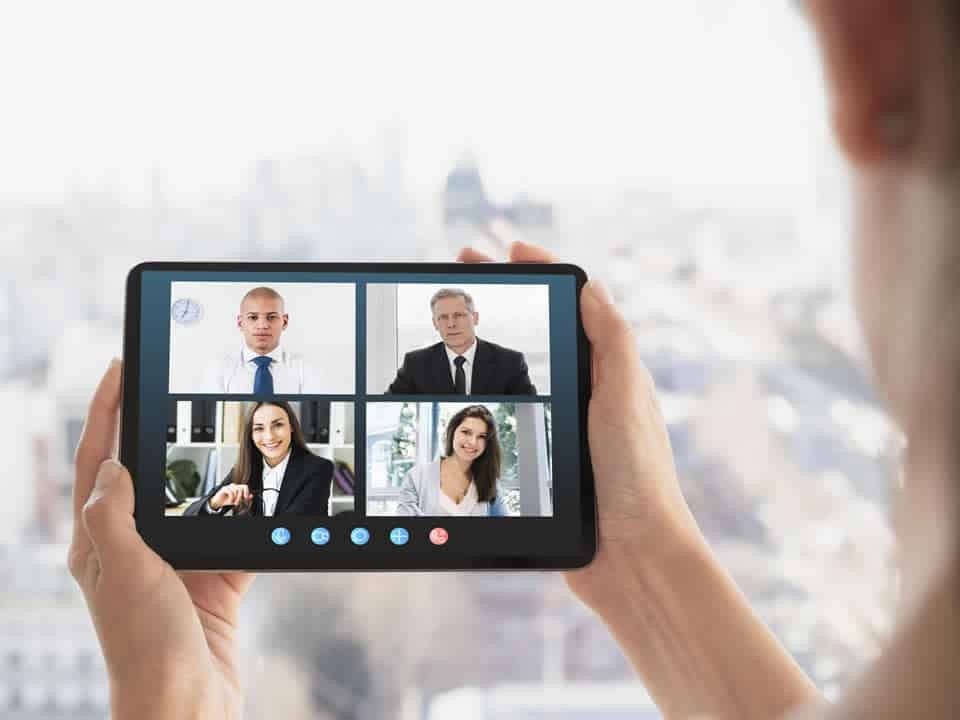 hands holding tablet while on a business video call