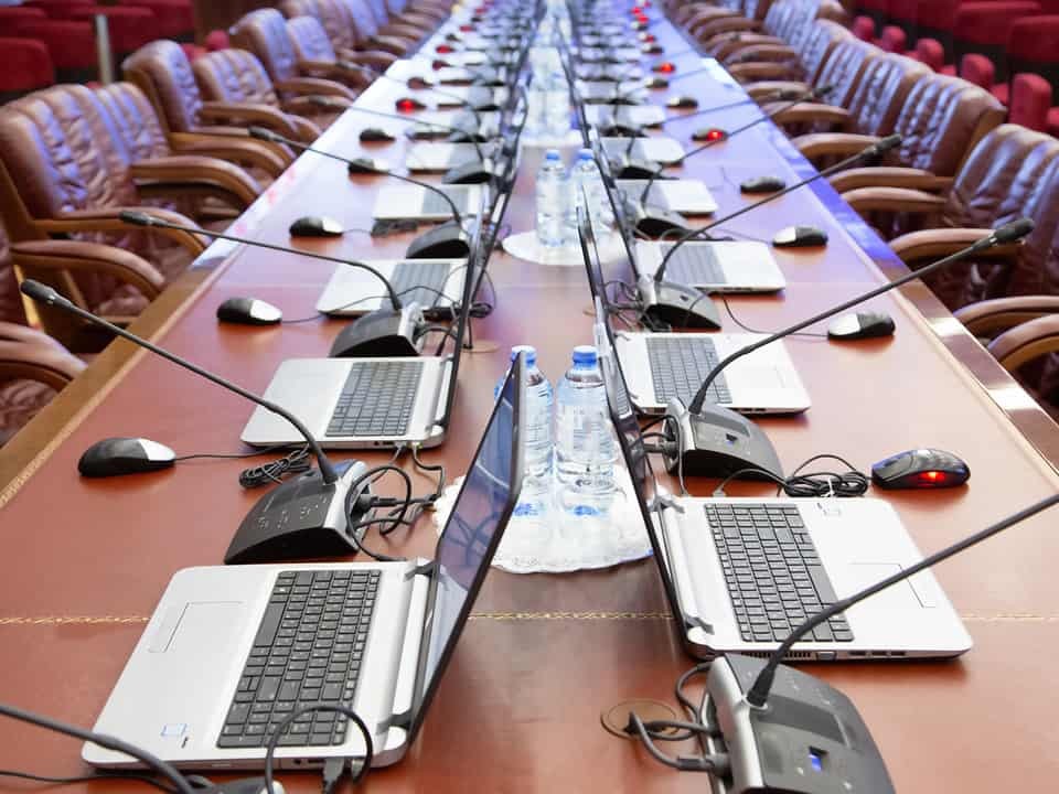 conference hall with multiple headsets, laptops and microphones