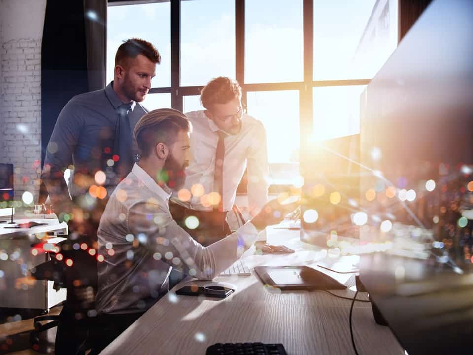 business consultants in an office working around a laptop